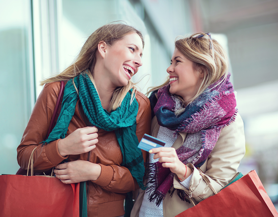 Happy friends shopping. Two beautiful young women enjoying shopp